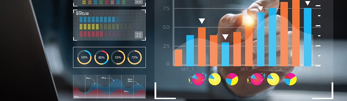 Analyst making a report with KPI and metrics displayed in a screen.